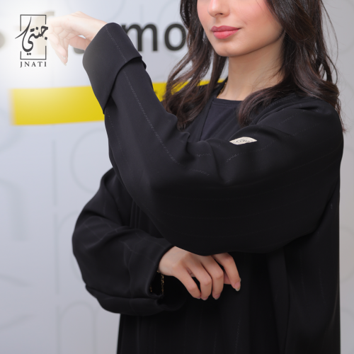 Black abaya made of Shangri-La fabric, decorated with lines of the same fabric