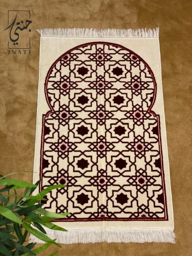 A patterned rug in maroon and beige.
