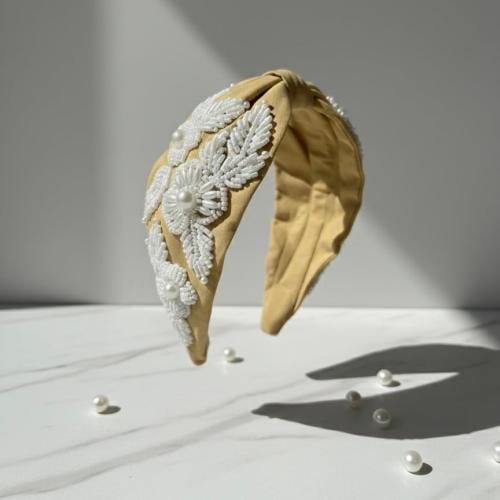 An attractive hairband decorated with white pearl...