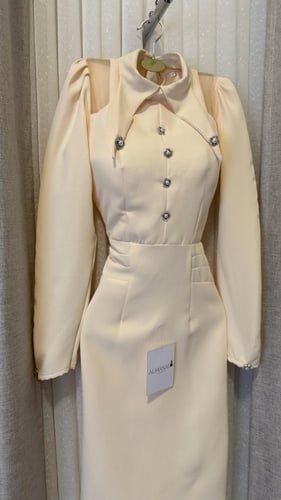 فستان ميدي ناعم باللون الكريمي بياقة هندسية وأزرار...