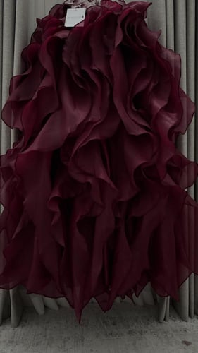 فستان سهرة عنابي بتوب مطرز وتنورة كشكش.