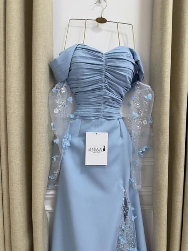 فستان سماوي بكسرات وكلفة مطرزة