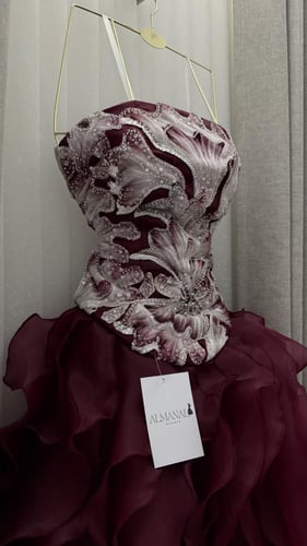 فستان سهرة عنابي بتوب مطرز وتنورة كشكش.