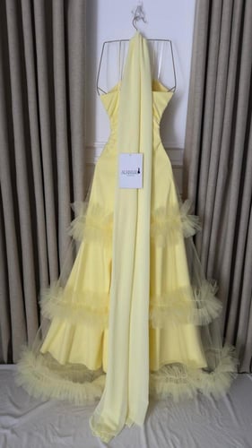 فستان سهرة أصفر بتنورة تول طبقات وتفاصيل لؤلؤية