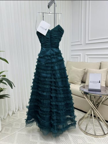 فستان سهره ناعم بكسرات أنثوية ولمسة فخامة زمردية