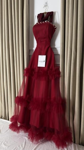 فستان سهرة أحمر بتفاصيل لؤلؤية وتنورة تول بطبقات ف...