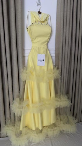 فستان سهرة أصفر بتنورة تول طبقات وتفاصيل لؤلؤية