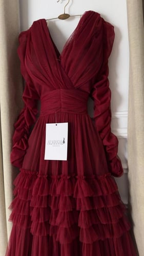 فستان سهره عنابي بكسرات متدرجة وأكمام منفوشة