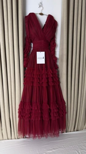 فستان سهره عنابي بكسرات متدرجة وأكمام منفوشة