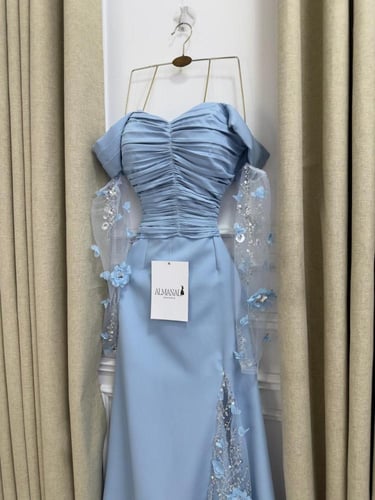 فستان سماوي بكسرات وكلفة مطرزة