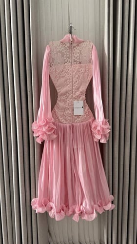 • فستان وردي ناعم بياقة مرتفعة وتفاصيل الدانتيل.