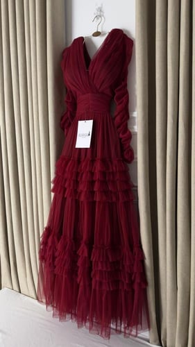 فستان سهره عنابي بكسرات متدرجة وأكمام منفوشة