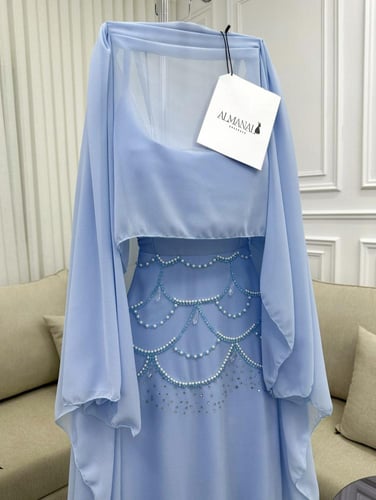 فستان شيفون سماوي بتفاصيل لؤلؤ وأكمام منسدلة