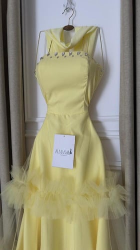 فستان سهرة أصفر بتنورة تول طبقات وتفاصيل لؤلؤية