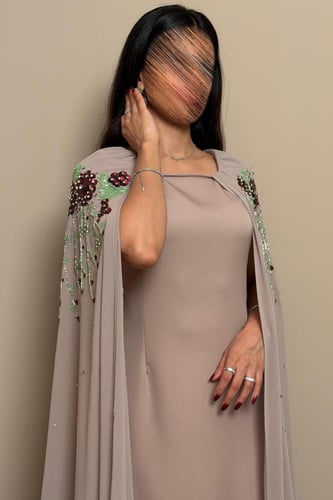 فستان ترابي بتطريز ورود عنابي وتفاصيل خرز فاخرة