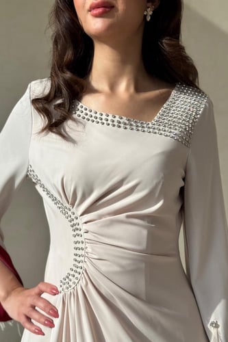 فستان بيج بتفاصيل لؤلؤية وأكمام خمري فاخرة