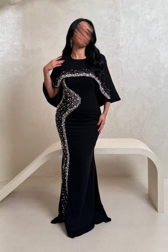 فستان أسود بتطريز لؤلؤ وتفاصيل شفافة