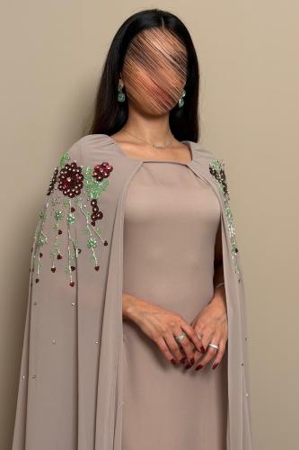 فستان ترابي بتطريز ورود عنابي وتفاصيل خرز فاخرة