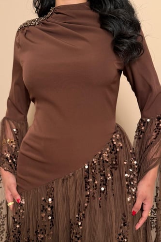 فستان سهرة بني بقصة مائلة وأكمام شفافة لامعة