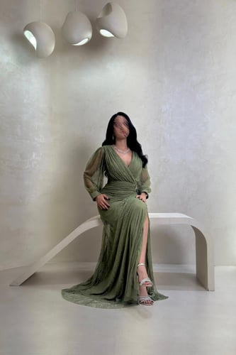 فستان دانتيل زيتي بتفاصيل كريستال وقصّة ملفوفة راق...