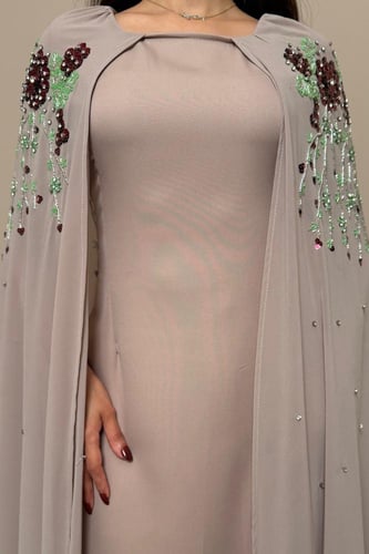 فستان ترابي بتطريز ورود عنابي وتفاصيل خرز فاخرة
