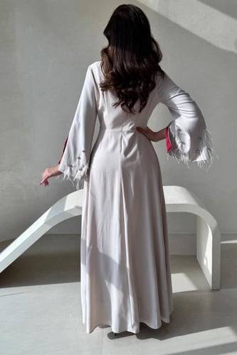 فستان بيج بتفاصيل لؤلؤية وأكمام خمري فاخرة