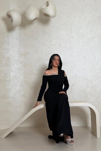 فستان أسود أنيق بتفاصيل لامعة على الأكتاف