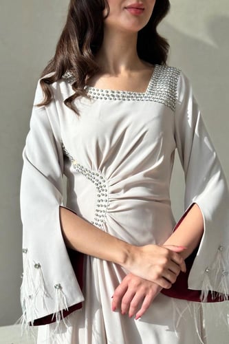 فستان بيج بتفاصيل لؤلؤية وأكمام خمري فاخرة