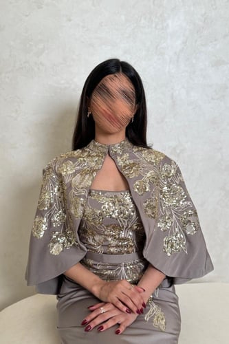 فستان بيج رملي بتطريز ذهبي فاخر وتصميم أنثوي راقٍ