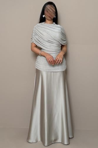 Long beige dress with a shimmering design and crystal details by Mleha.