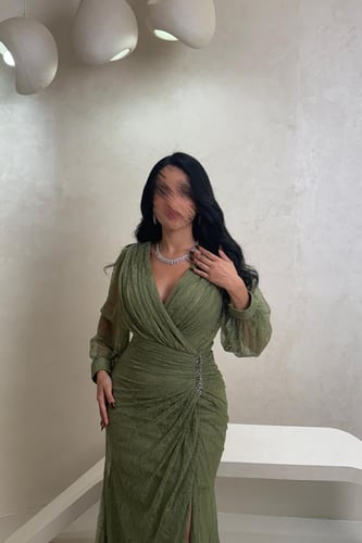 فستان دانتيل زيتي بتفاصيل كريستال وقصّة ملفوفة راق...