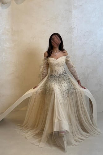 فستان بيج بتصميم تل مطرز وبأكمام شفافة فاخرة