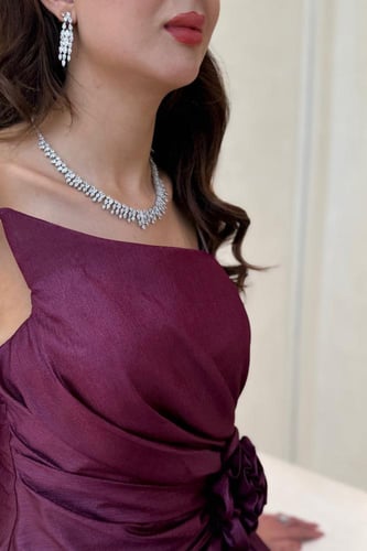 فستان عنابي بقصة كت ووردة جانبية وفتحة ناعمة