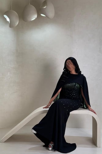 فستان أسود بتفاصيل خضراء لامعة بتصميم فاخر