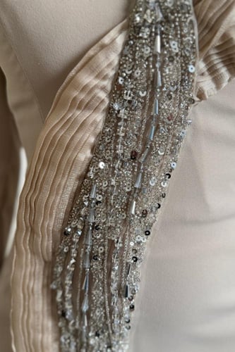 فستان بيج مطرز بتفاصيل فخمة على الكتف