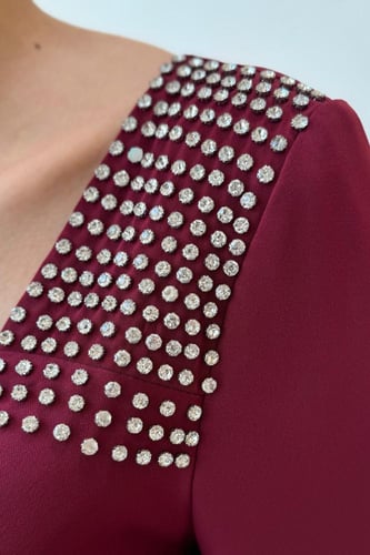 فستان خمري بتطريز ناعم وأكمام منسدلة بتفاصيل ريش