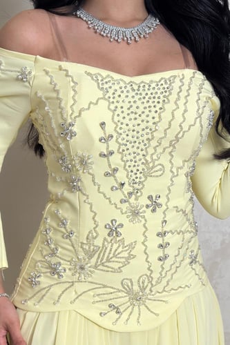 فستان أصفر بتطريز كريستالي وقماش انسيابي فخم