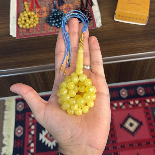 A prayer bead with a clear yellow color