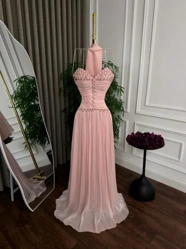 فستان بلونه الوردي الناعم (Blush Pink) وتصميمه الأنثوي الراقي: