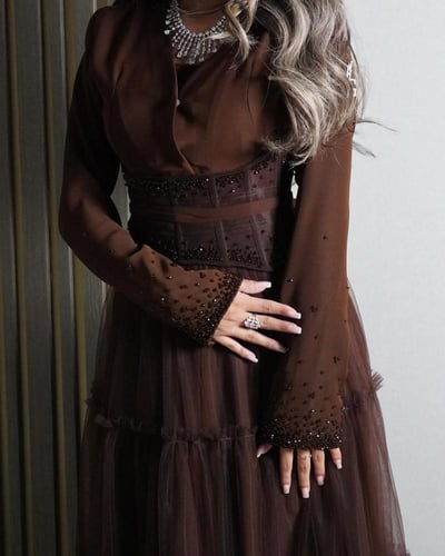 فستان بني يجمع بين الحشمة والأنوثة