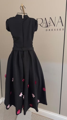 فستان أسود أنيق مزين بورود ملونة بتدرجات الوردي فو...