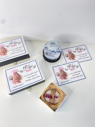 علب هدايا بتغليف راقٍ، بطاقة تهنئة، وقطعة فنية مزي...