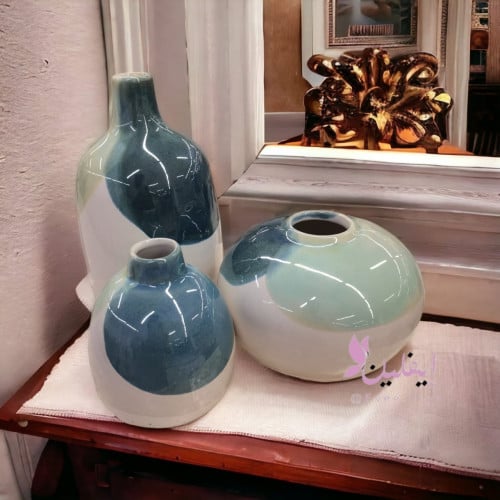 فازه سراميك صغيره بلون الابيض و الاخضر الغامق و ال...