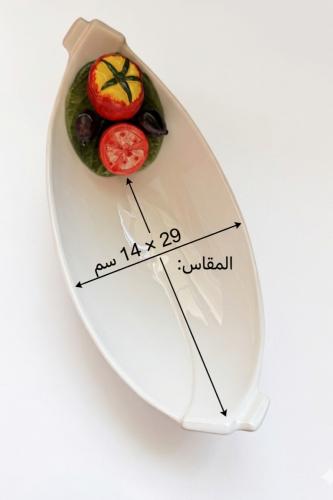 طبق تقديم سيراميك بتصميم "قارب" مزين بثمار الطماطم والزيتون