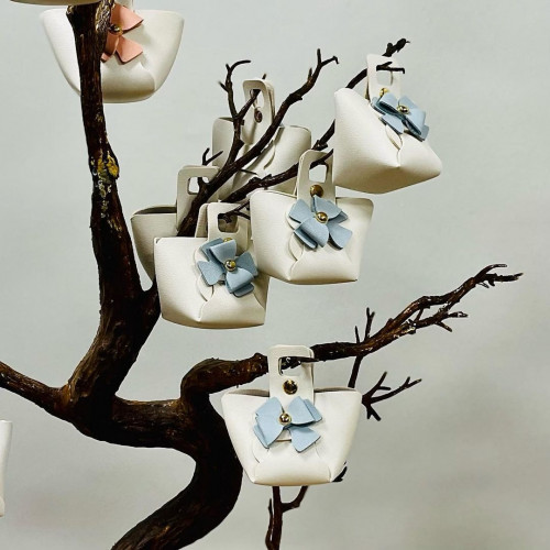 توزيعات جلد بشكل شنطة بلون اوف وايت وكبسات ذهبي و...