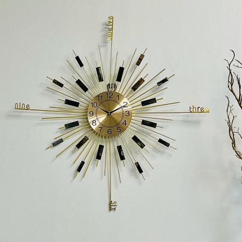 ساعة حديد ذهبي بشكل دائري واشعة الشمس بارقام سوداء...
