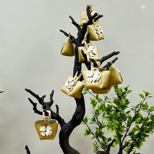 توزيعات جلد بشكل شنطة بلون ذهبي وكبسات ذهبي و عقدة...