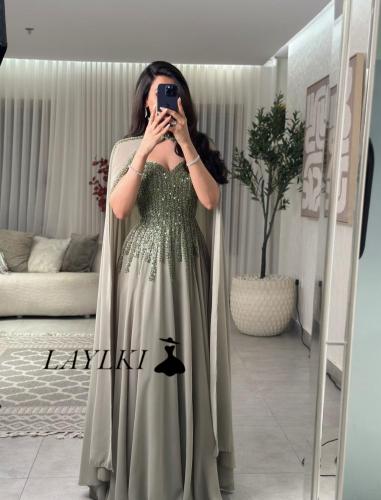 Olive dress with shiny embroidery and a luxurious cape