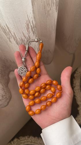 A prayer bead with a clait turban, metal, sand col...