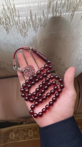 A red transparent plastic prayer bead with copper...